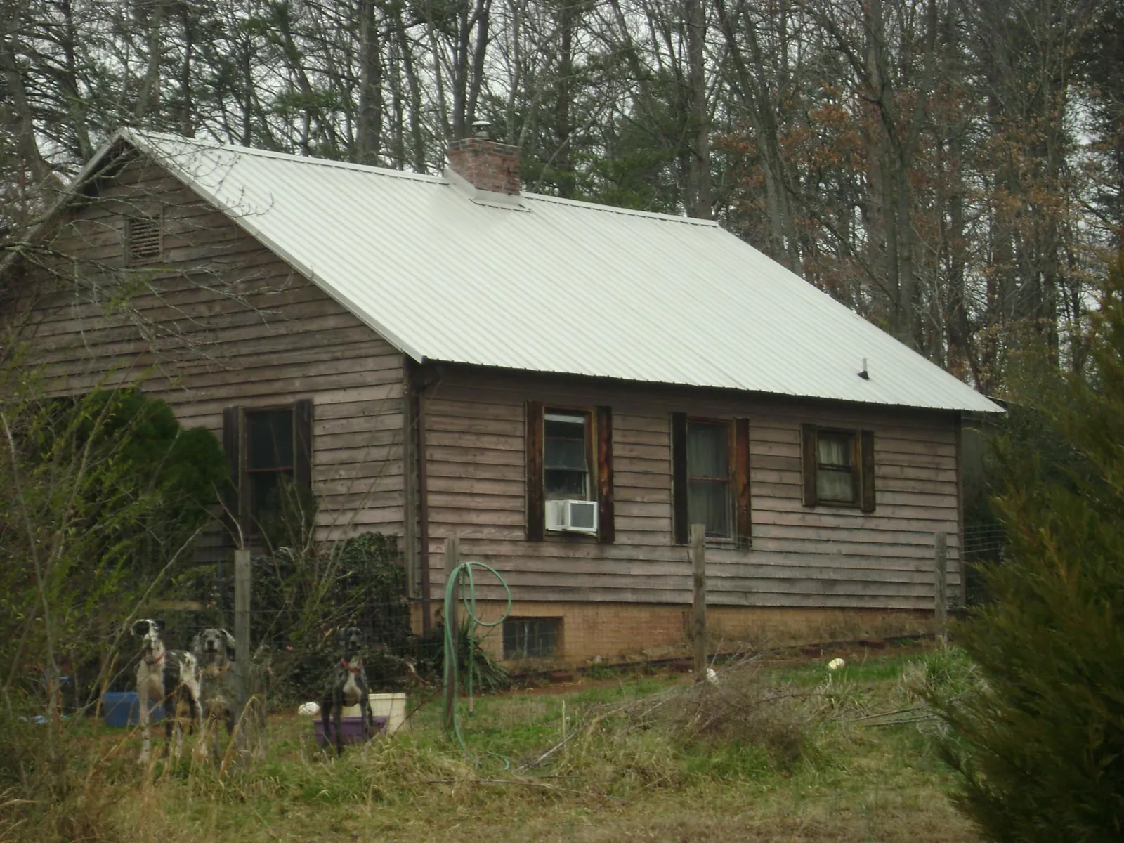 White metal roof on an old wood sided farmhouse, from a Asphalt Shingle Roof Repair job in Rockville